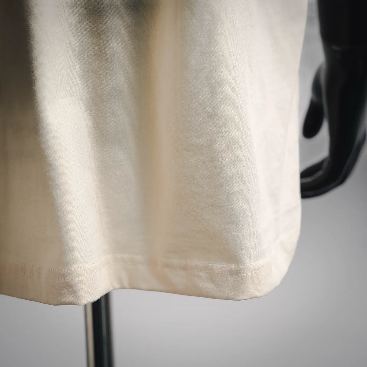 Off-white T-shirt hem with neat stitching and drape