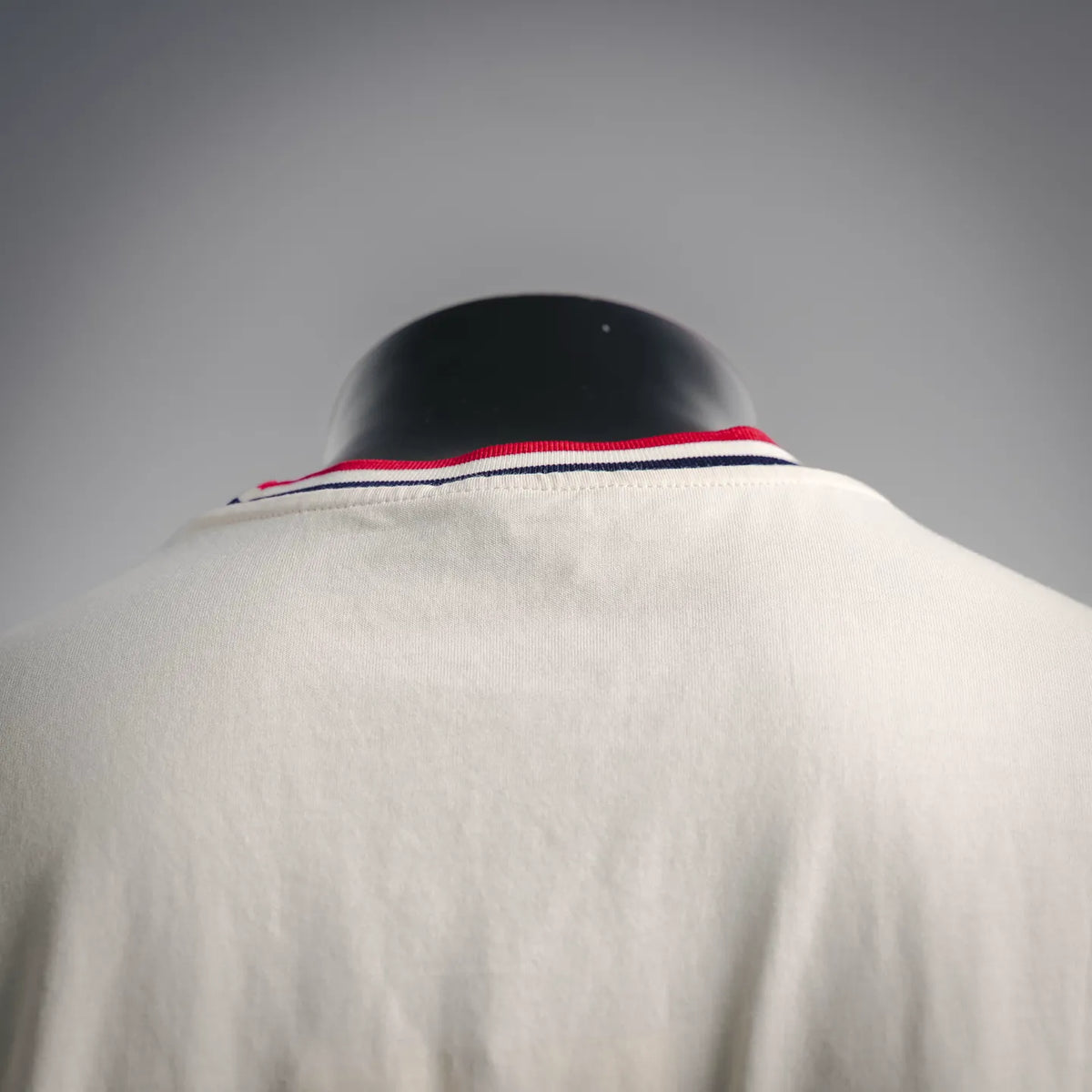Off-white crewneck T-shirt with red, white, and navy ribbed collar