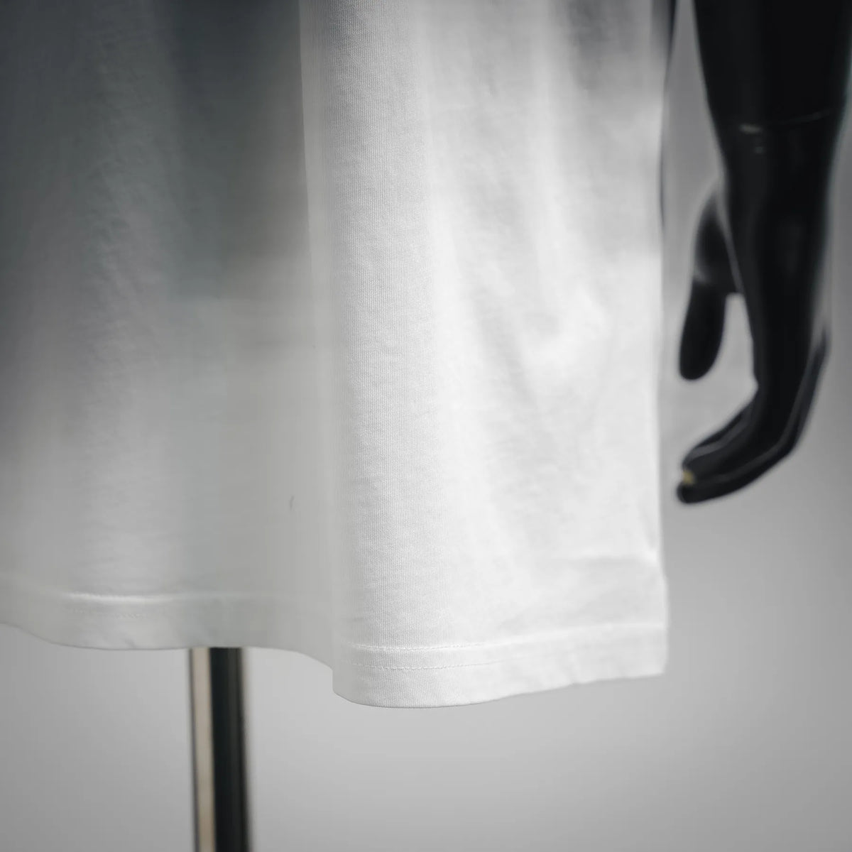 White short-sleeve T-shirt hem with straight cut on a mannequin