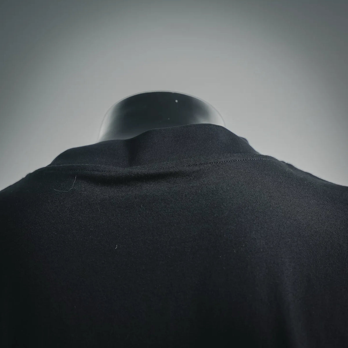 Moncler dark mock-neck T-shirt collar and shoulder seam close-up