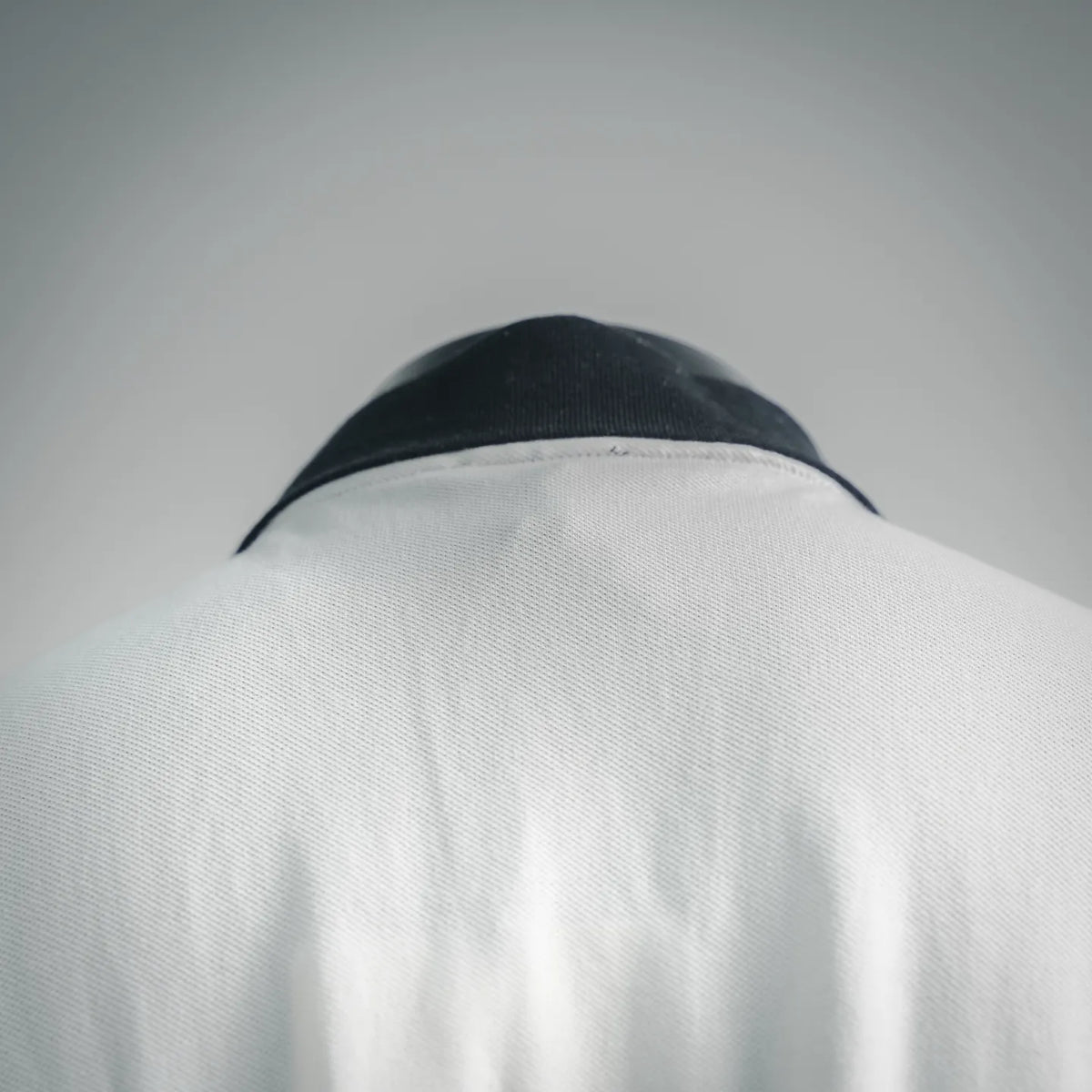 White polo shirt back with black collar trim