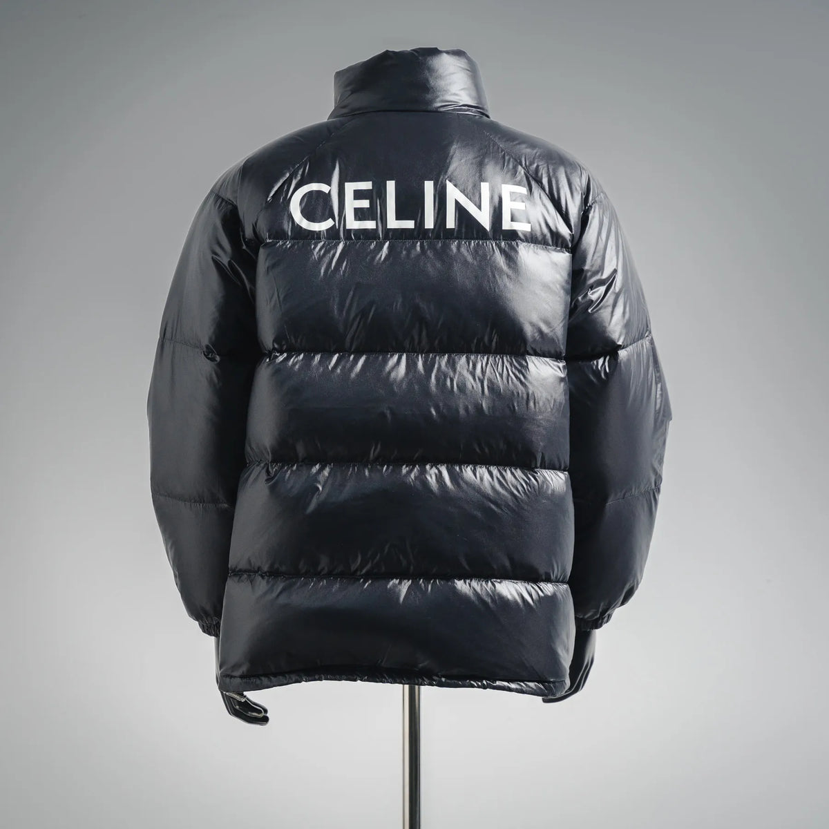 Black puffer coat back view with large CELINE logo on yoke