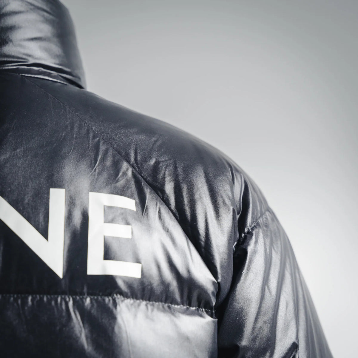 Black puffer coat back with oversized CELINE lettering across shoulder