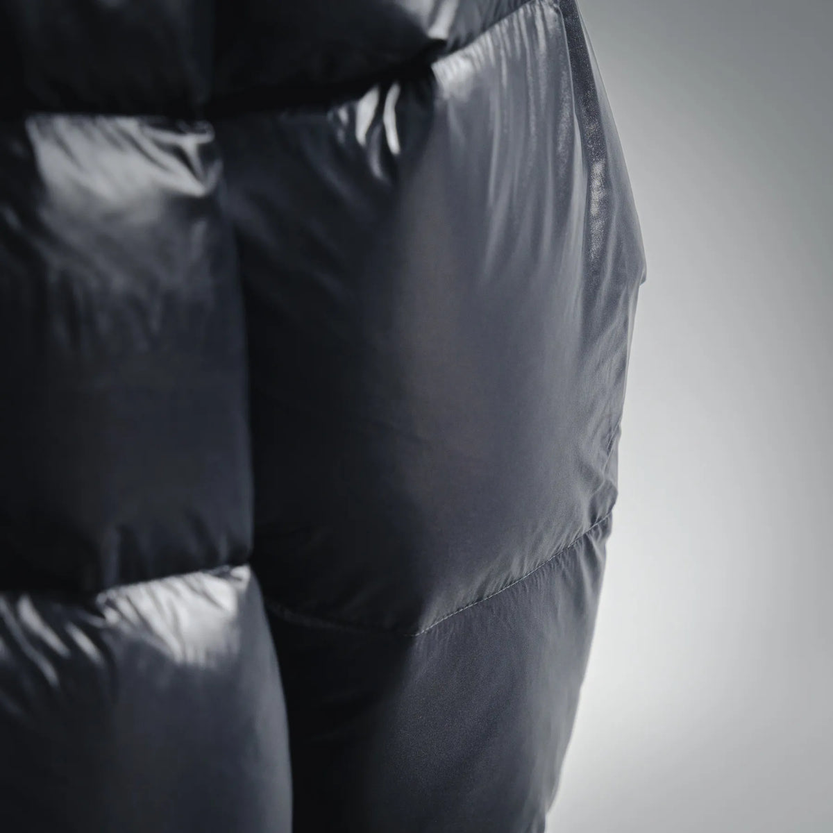 Black puffer coat close-up of quilted panel and smooth outer finish