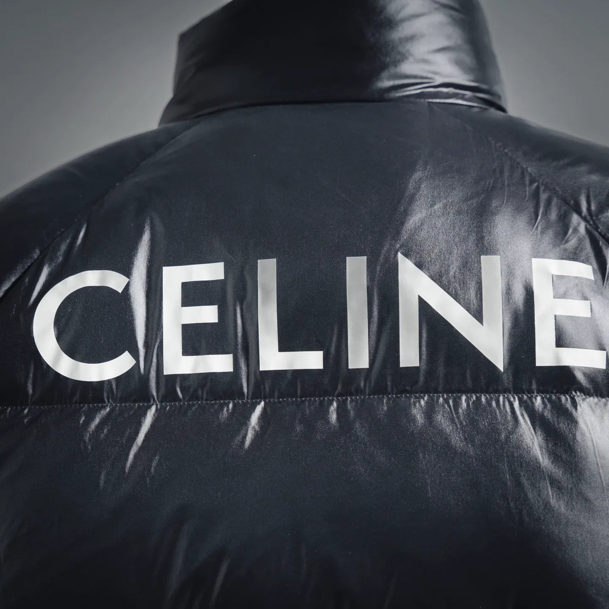 Black puffer coat shoulder detail with CELINE logo strip and stitched seams