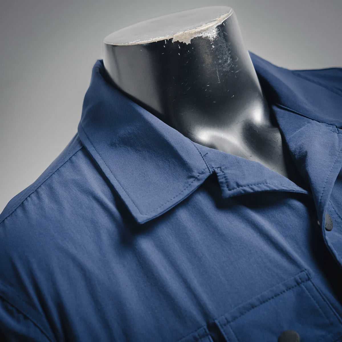 Blue jacket with pointed collar, button placket, and chest flap pocket