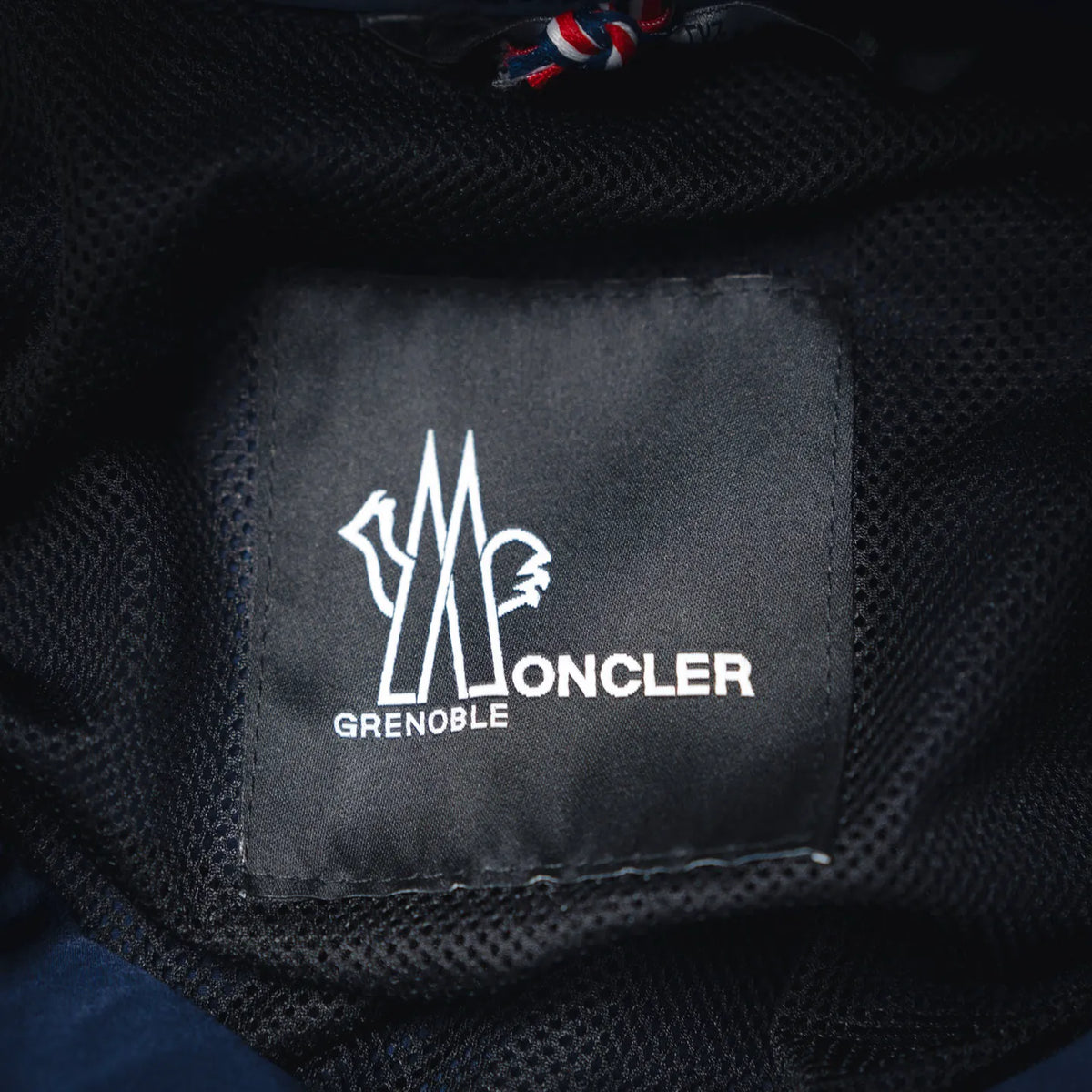 Moncler Grenoble logo label on dark inner fabric lining
