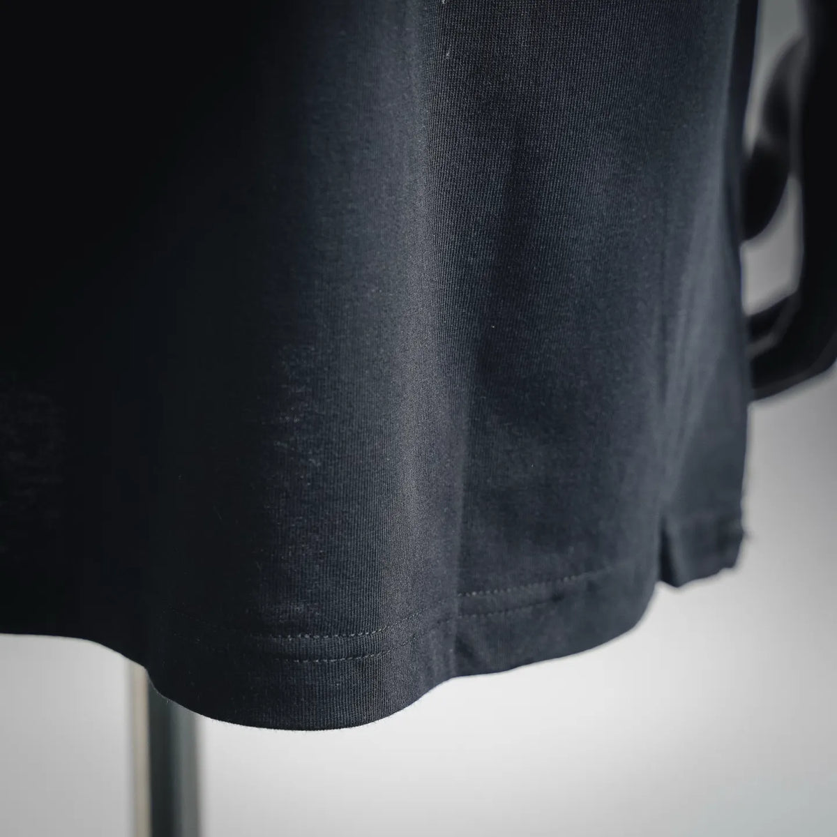 Men's Moncler black T-shirt hem close-up with neat stitching