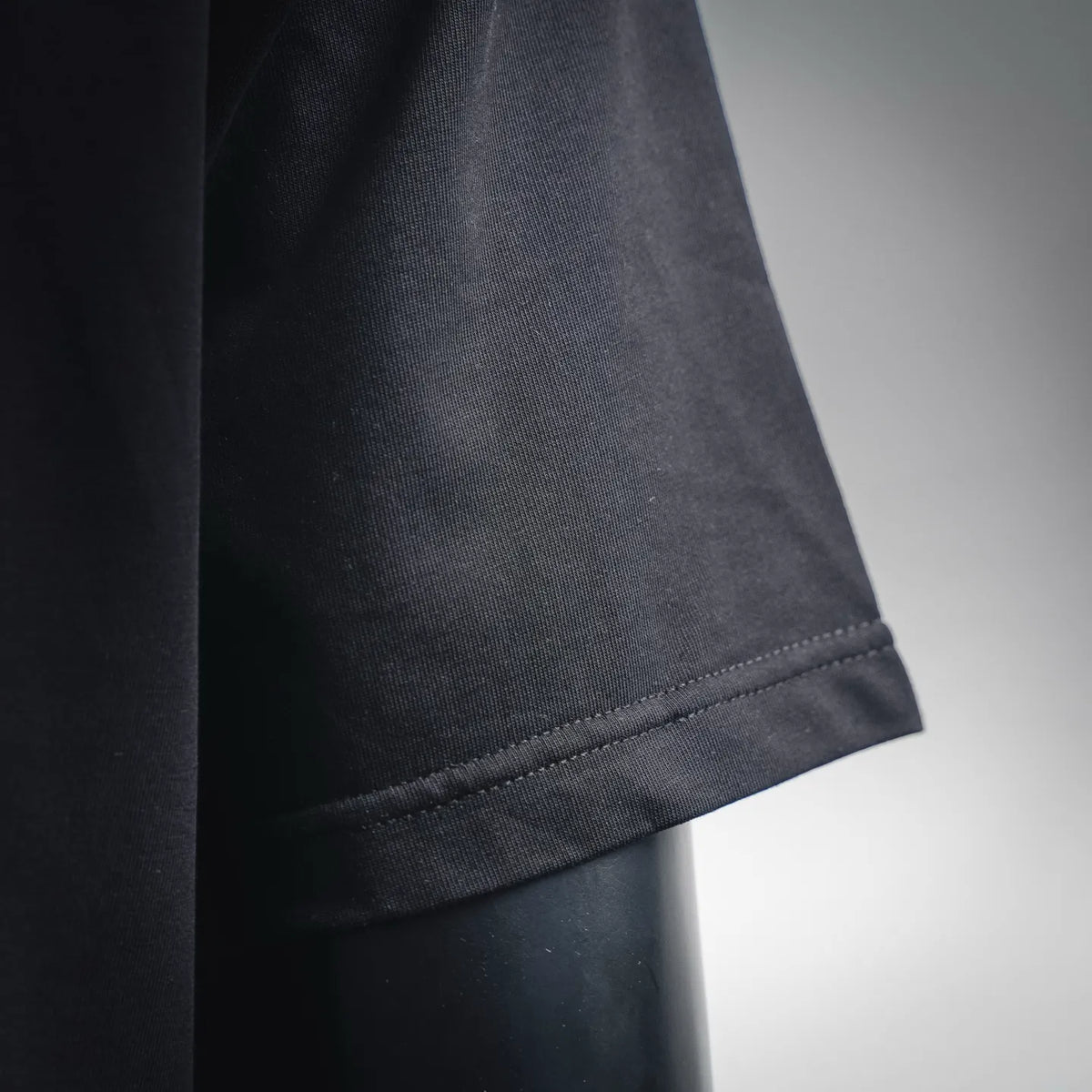 Black T-shirt sleeve cuff with double-stitched hem