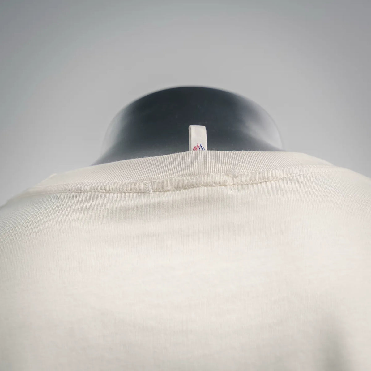 Moncler T-shirt neckline detail in light cream with small collar label