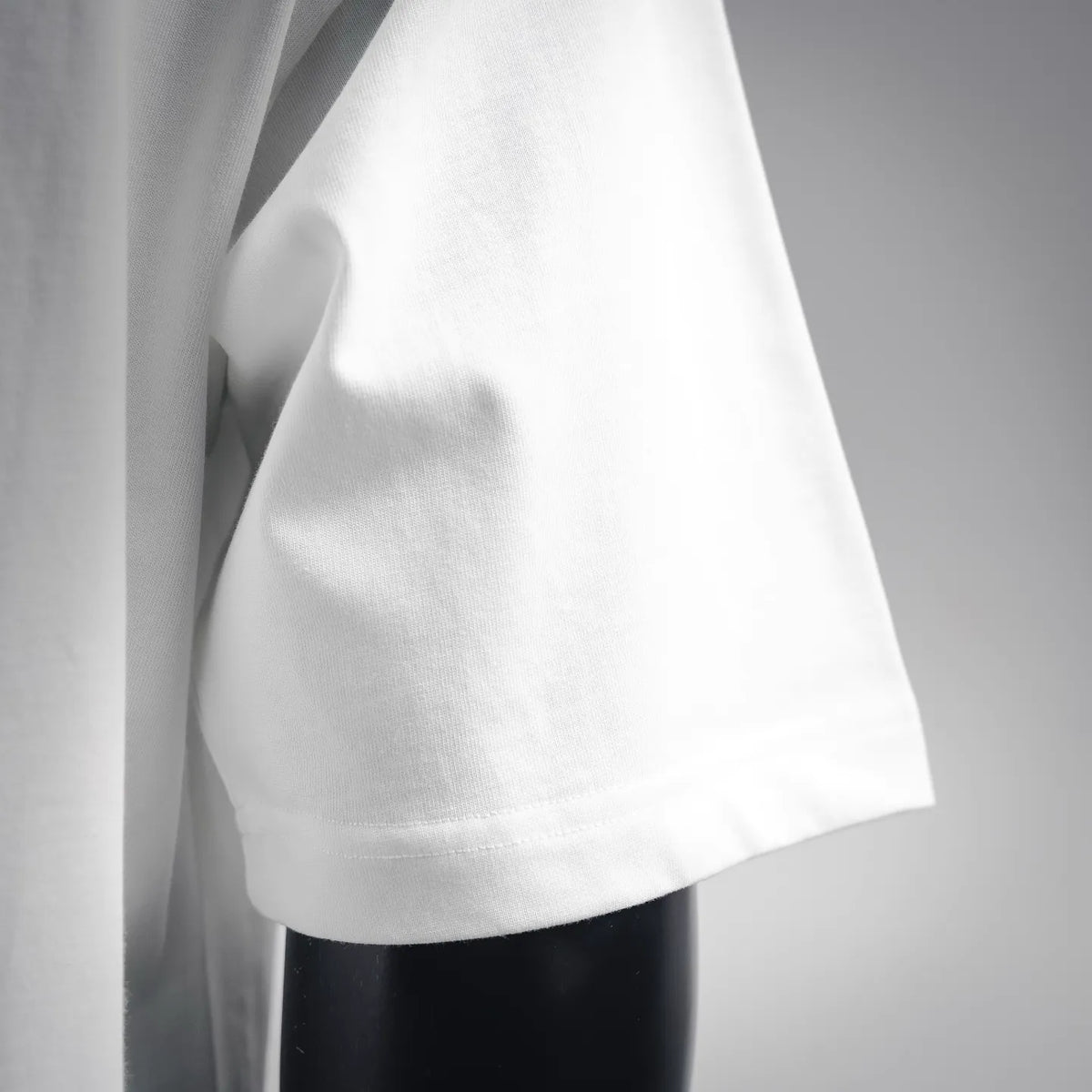 White Moncler short-sleeve T-shirt side view showing soft fabric and hem stitching