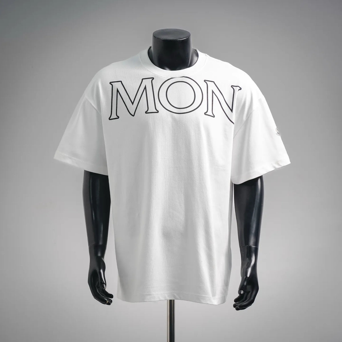 White Moncler short-sleeve T-shirt with MON graphic print at chest.