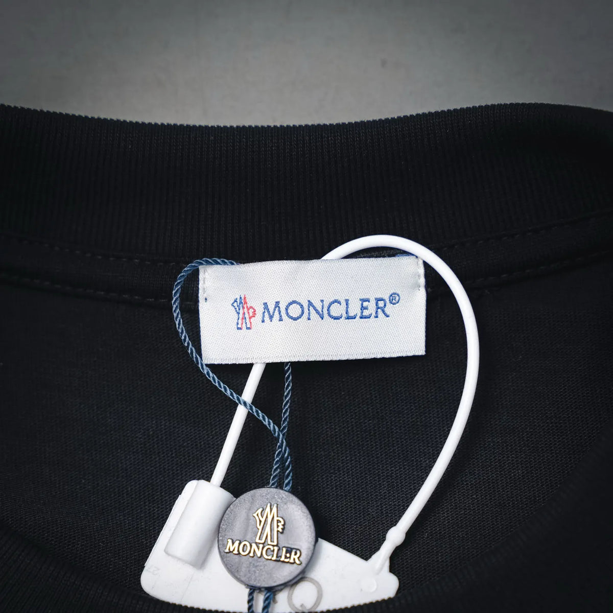 Moncler black T-shirt neck label and small hanging brand tag detail