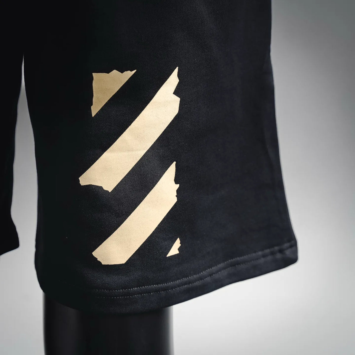 Dark shorts hem with embroidered diagonal stripes graphic in beige