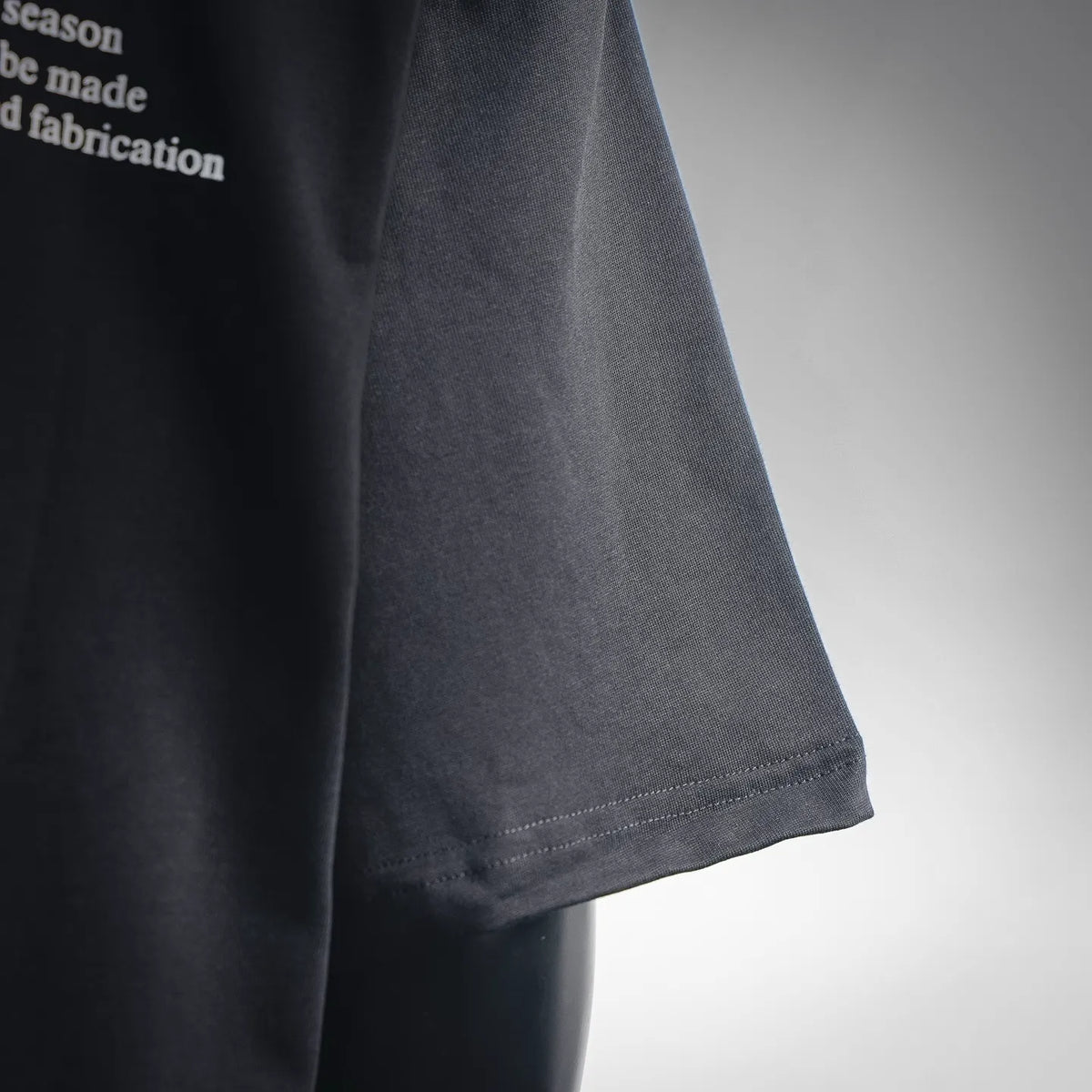 Black short-sleeve T-shirt sleeve hem and side seam close-up