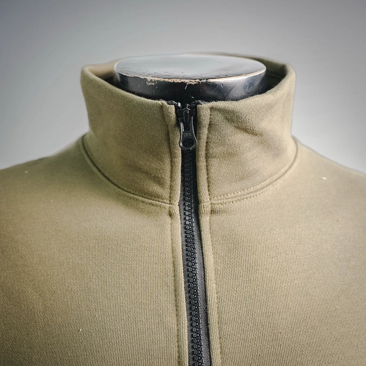 Olive half-zip sweatshirt with black zipper and high neck