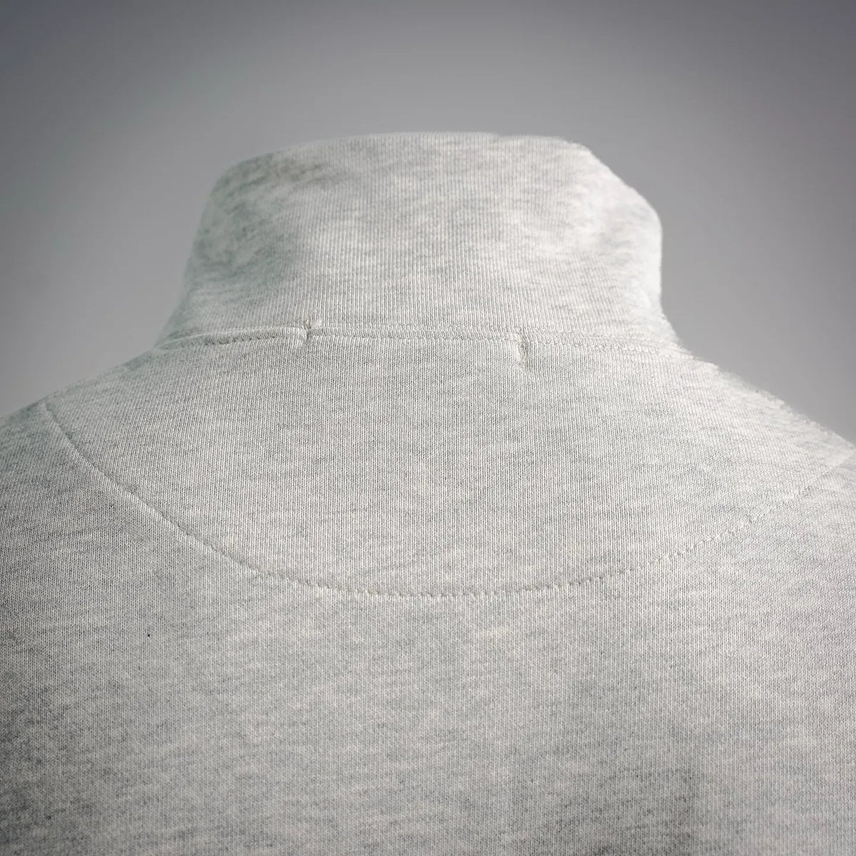 Light gray high neckline sweatshirt close-up of textured collar and shoulder seam