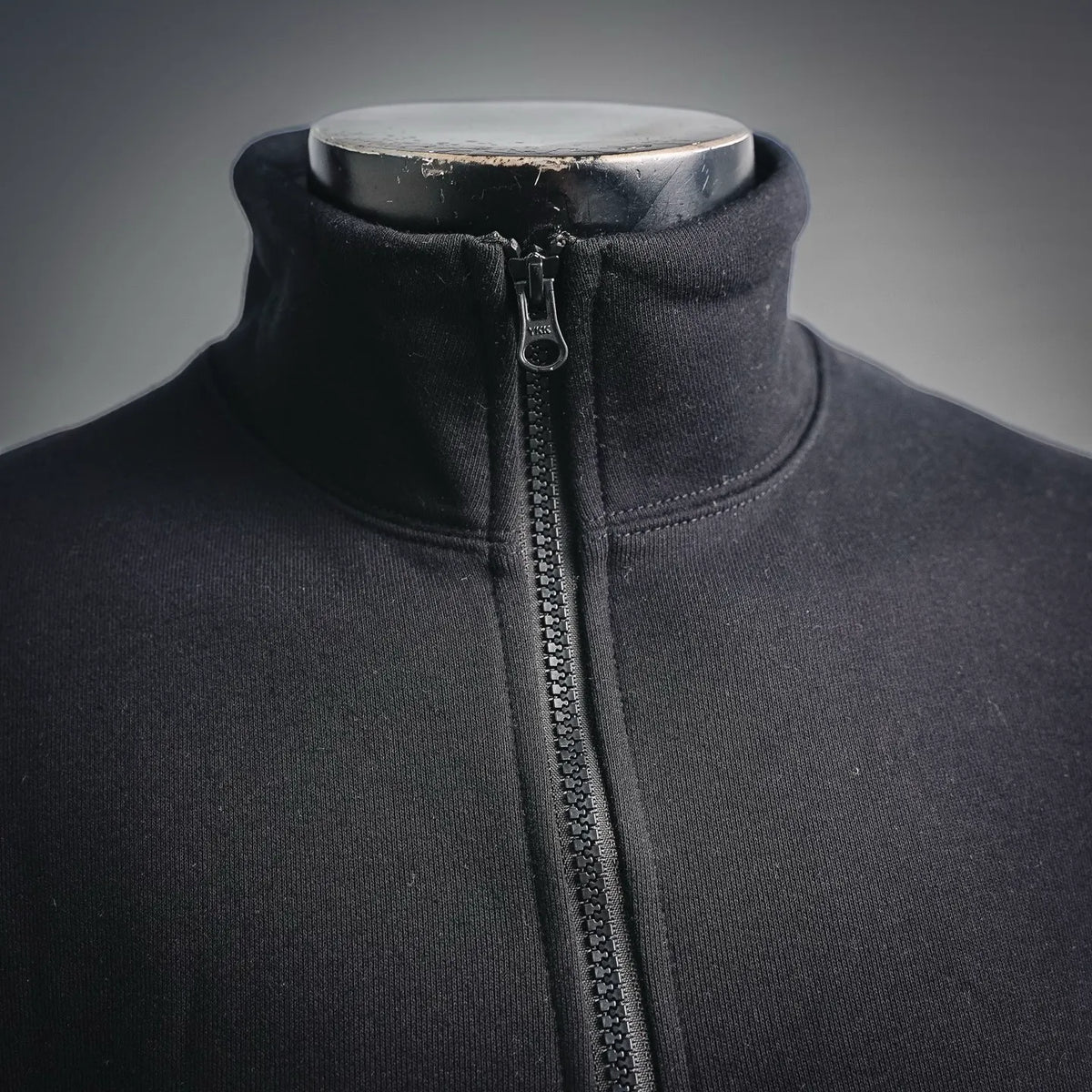 Black stand-collar sweatshirt with visible metal zipper and zipper pull