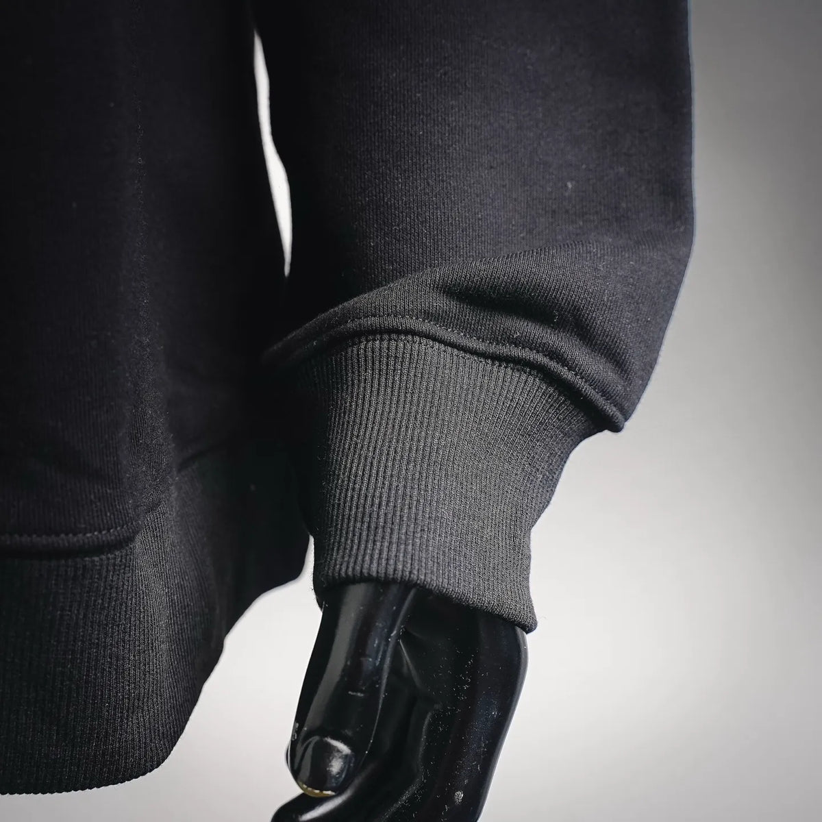 Black sweatshirt sleeve with ribbed cuff and curved hem