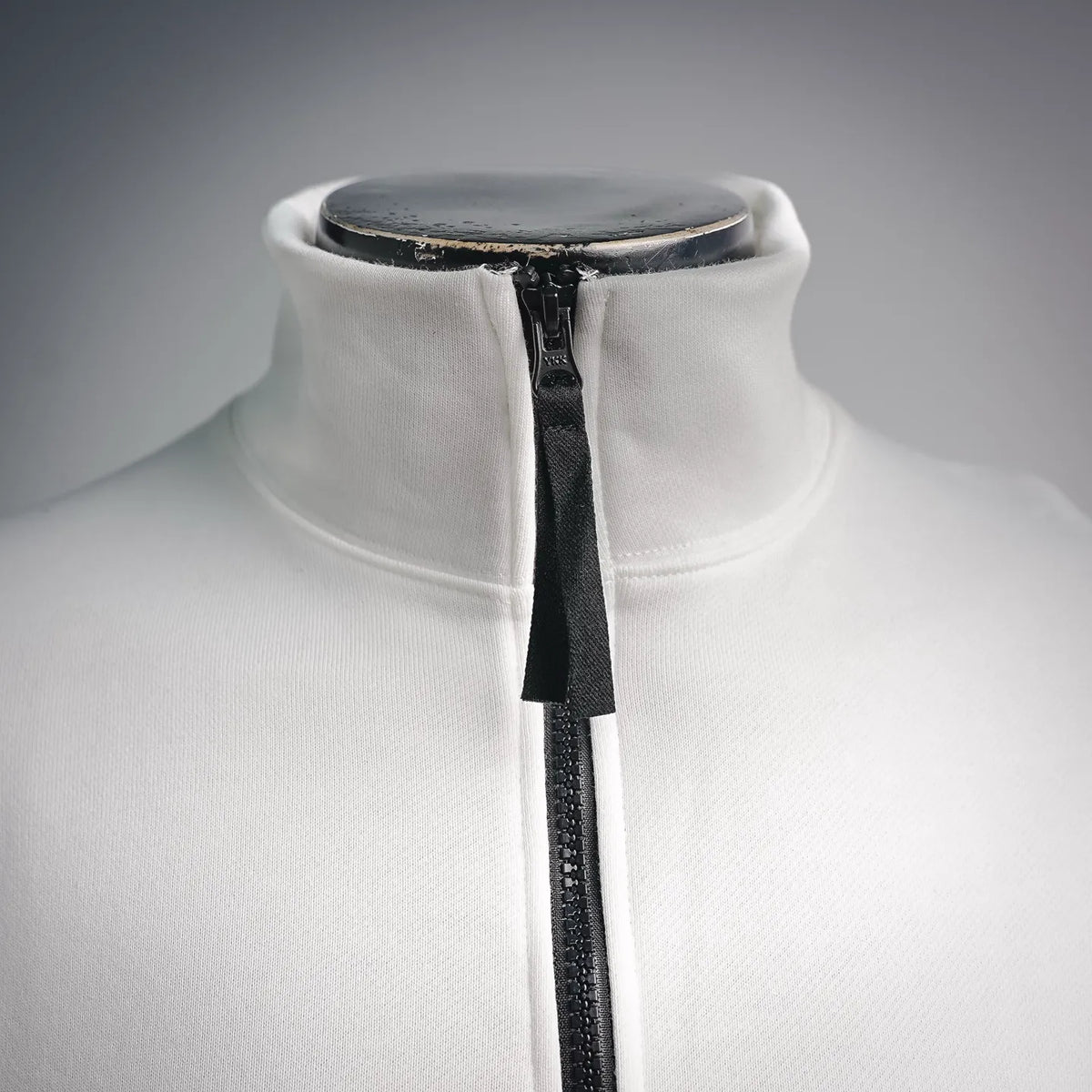 White sweatshirt with black quarter-zip front and high mock collar