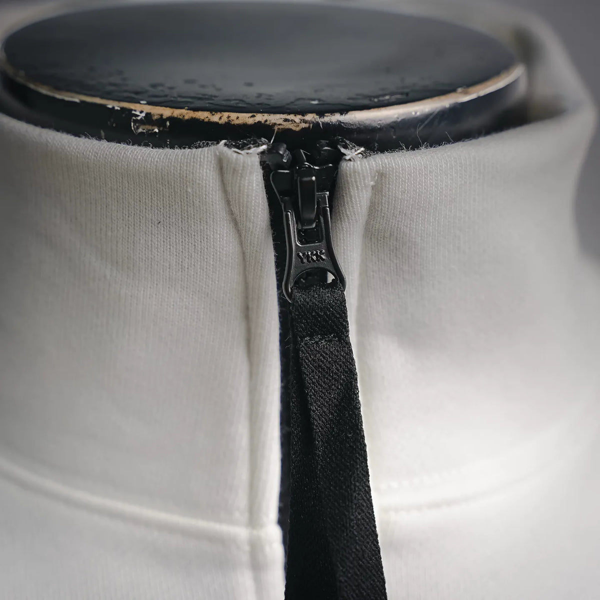 White sweatshirt with black zipper and top-stitch placket detail at neck