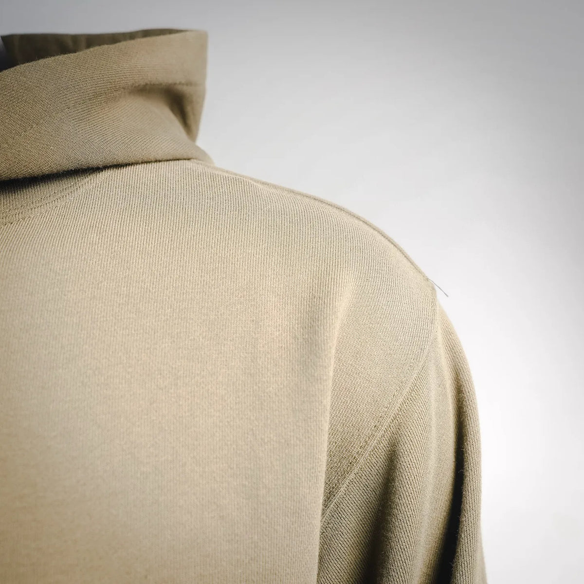 Olive hoodie back shoulder seam and textured knit fabric close-up