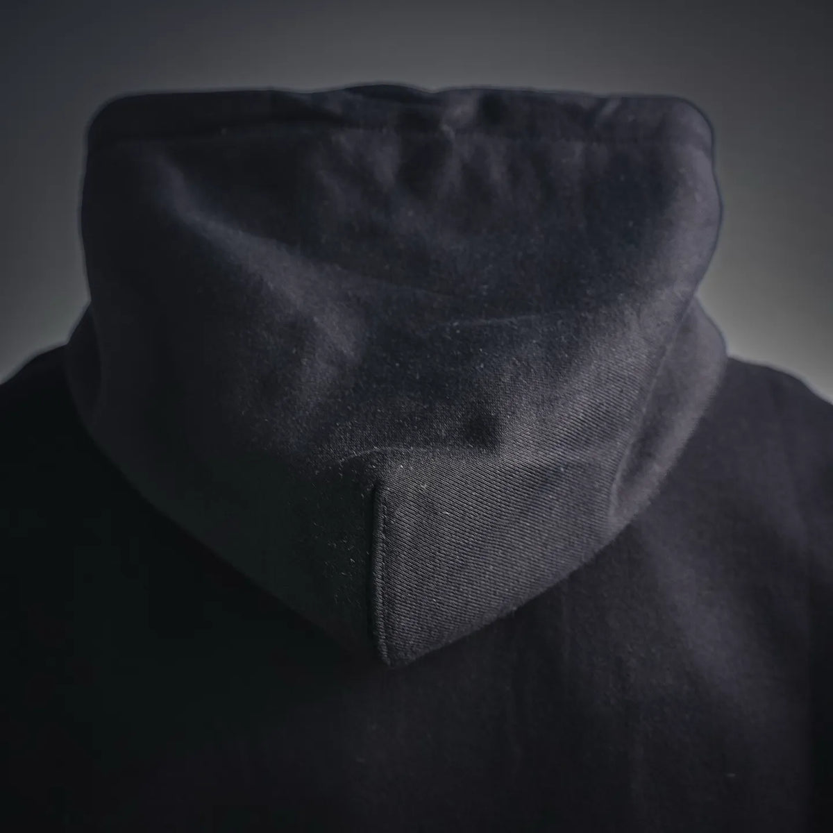 Close-up of black hoodie hood with fabric texture and inner seam detail