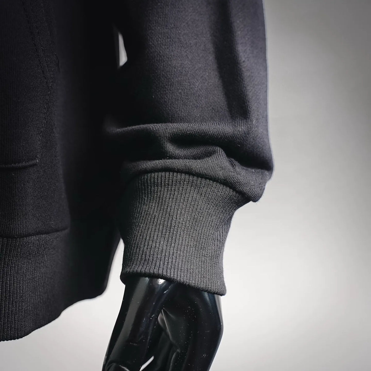 Black hoodie cuff with ribbed knit hem and sleeve edge