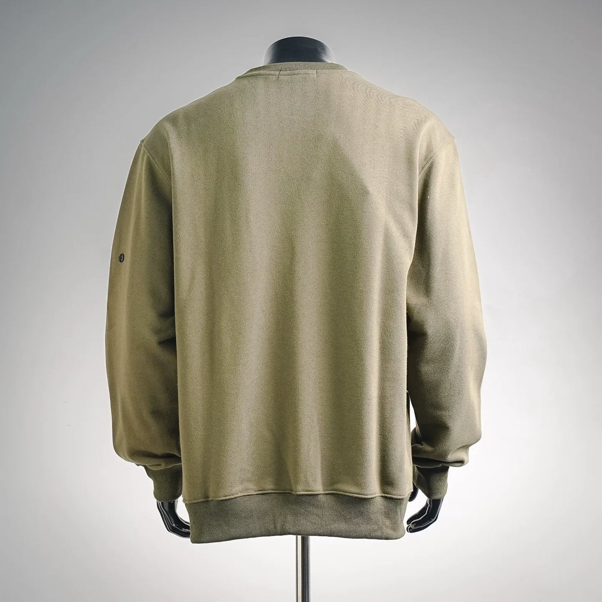 Olive green crewneck sweatshirt, back view with ribbed hem