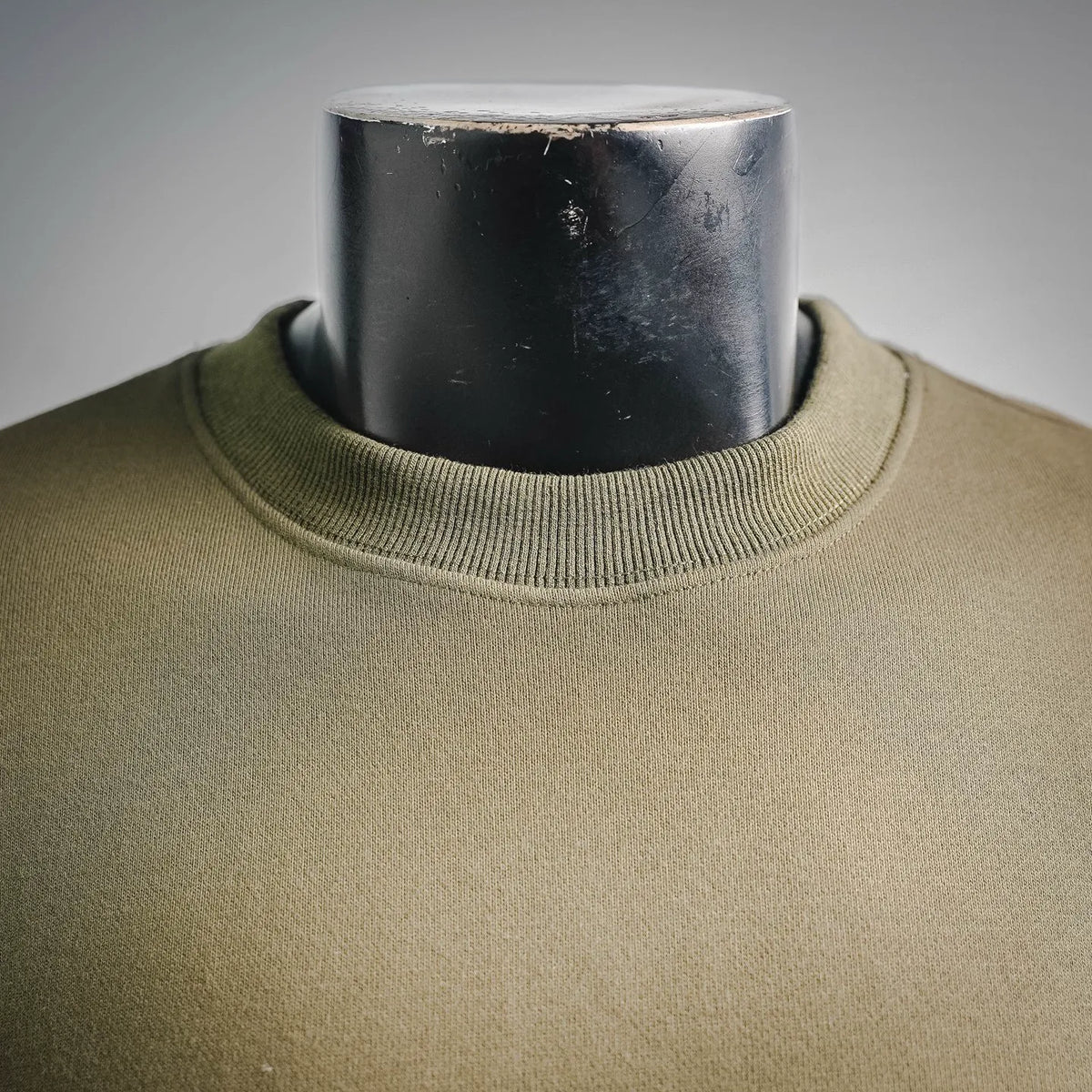 Olive knit crewneck sweatshirt collar close-up, ribbed neckline