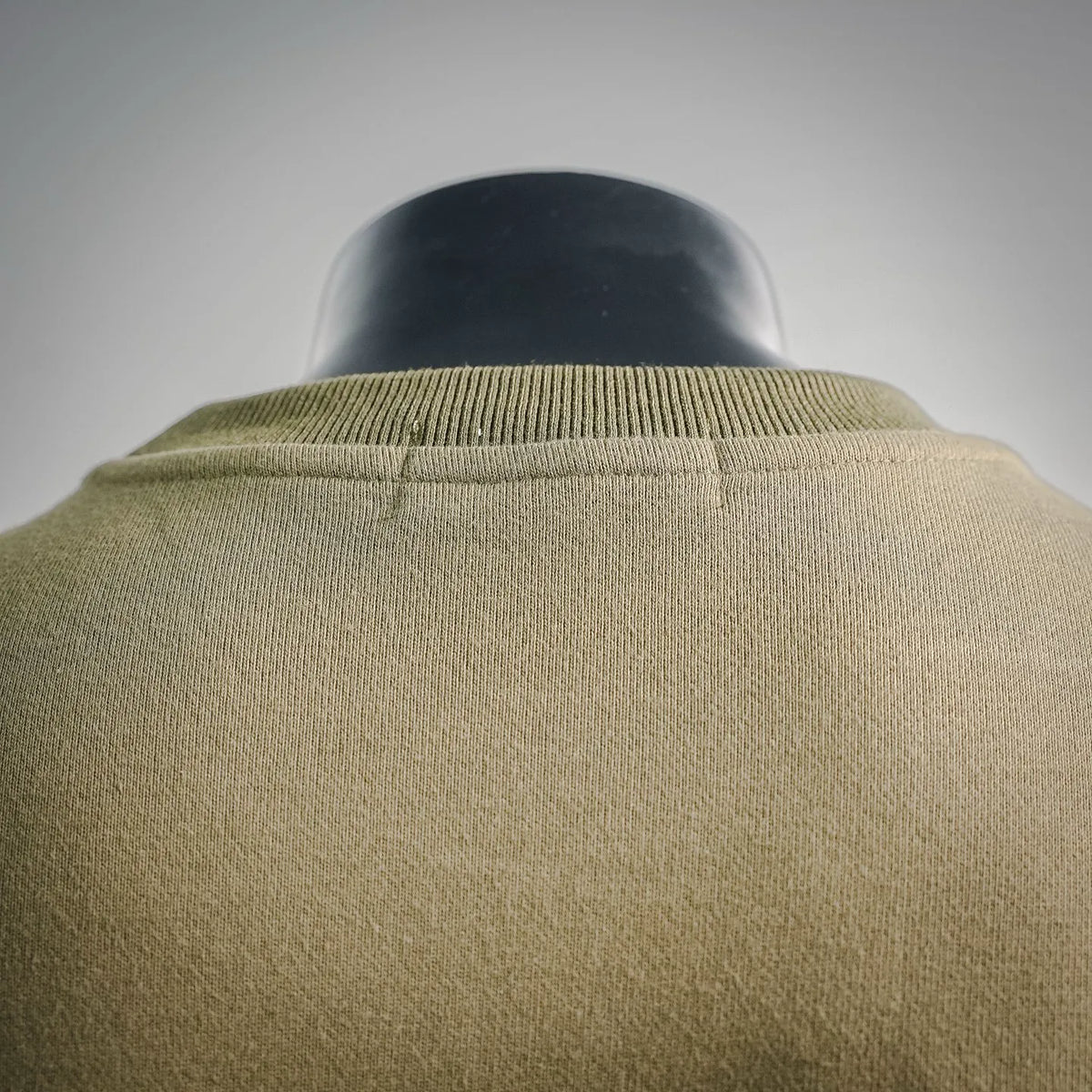 Olive green sweatshirt back yoke and ribbed collar close-up