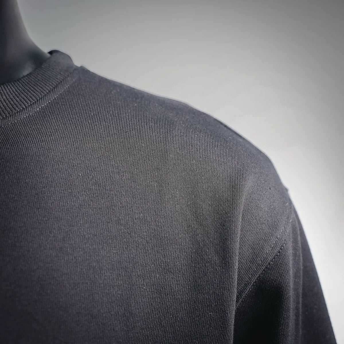 Dark crewneck sweatshirt with ribbed neckline and textured knit fabric.