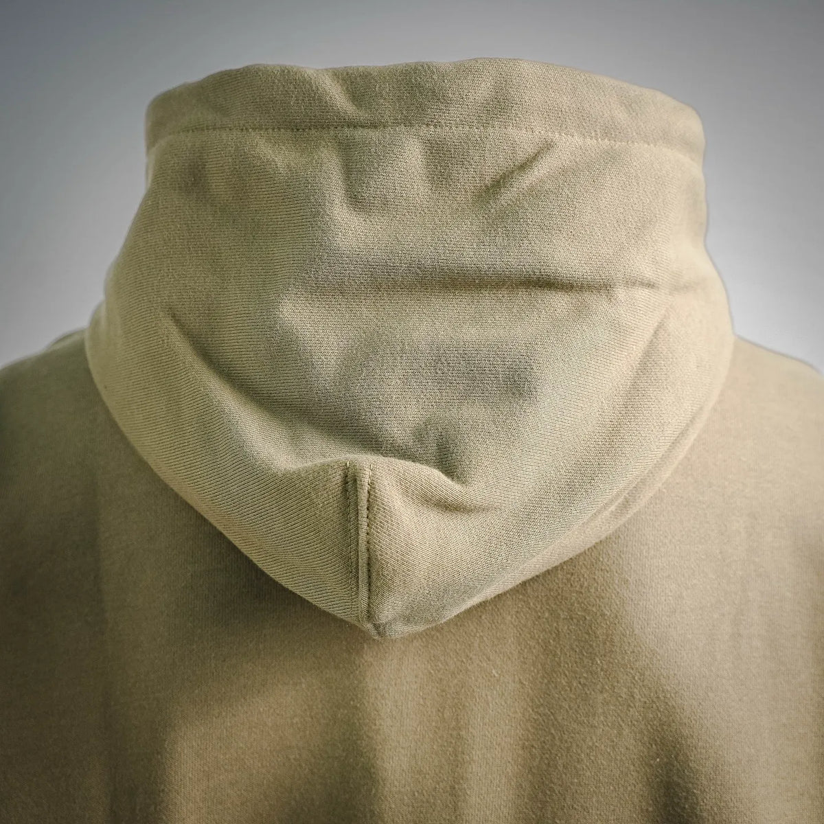 Olive hood with adjustable drawstring ends, close-up