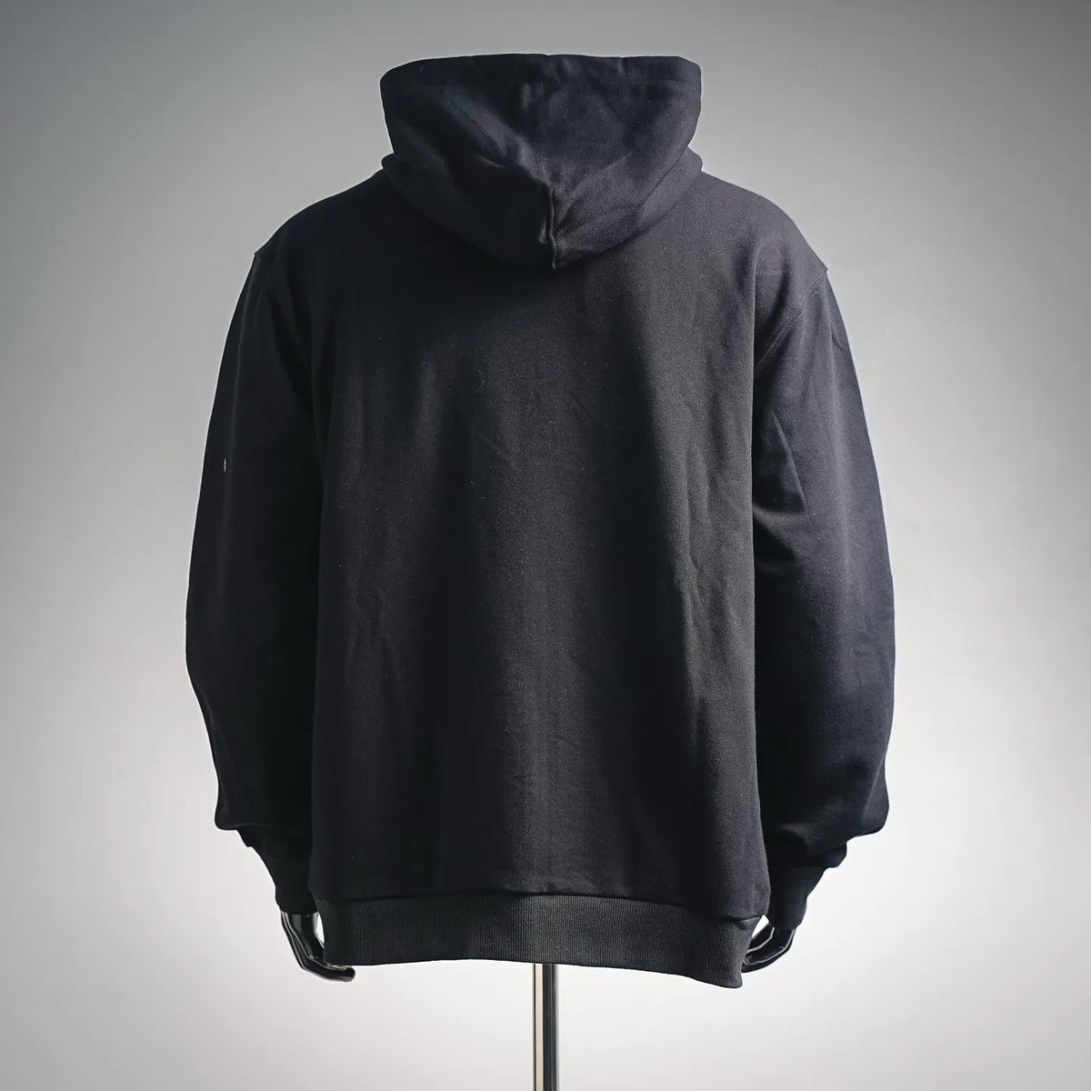 Black pullover hoodie with attached hood and ribbed hem