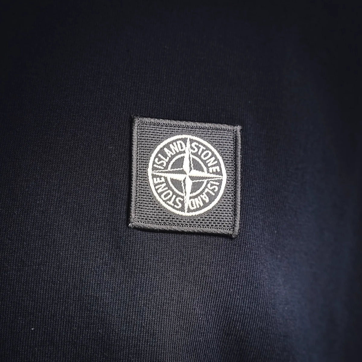 Stone Island patch on navy crewneck sweatshirt chest