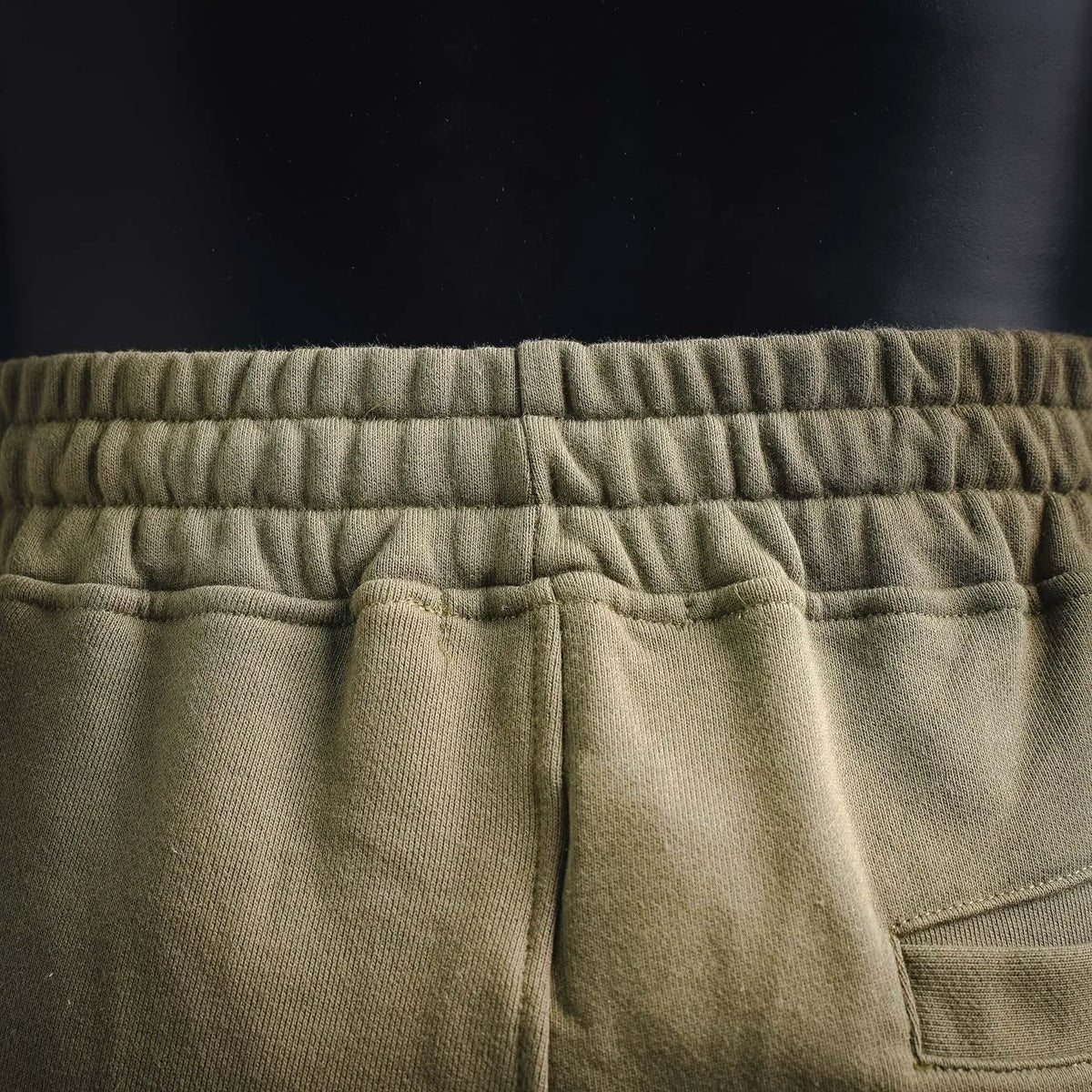 Olive jogger pants back waistband seam and curved pocket detail