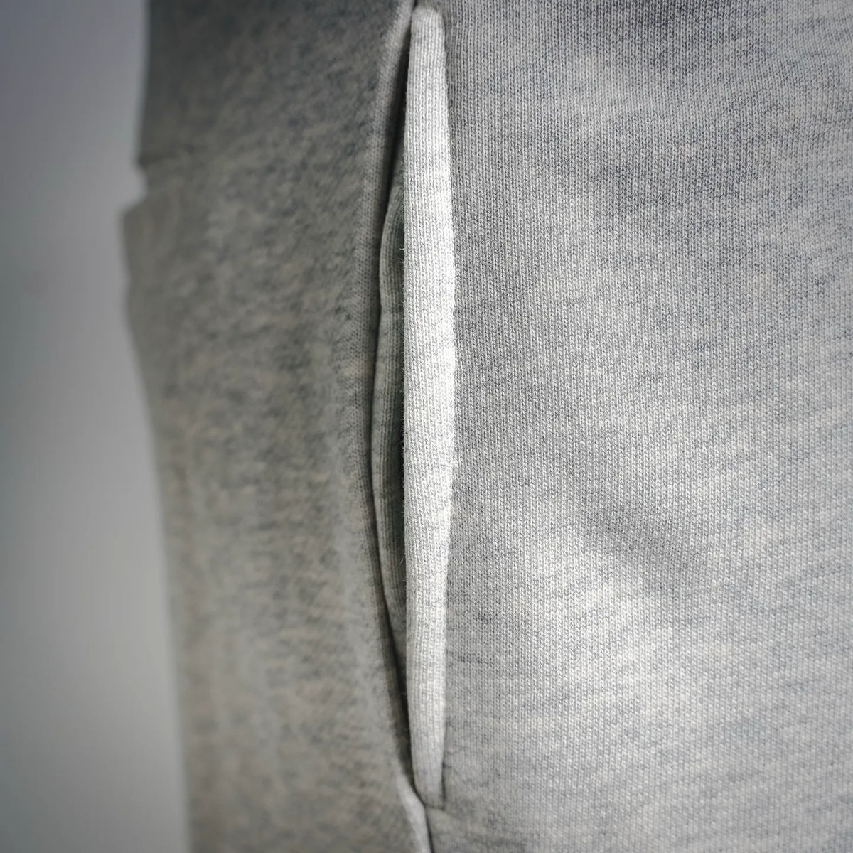 Light gray Stone Island jogger pants, ribbed hem with side seam close-up.