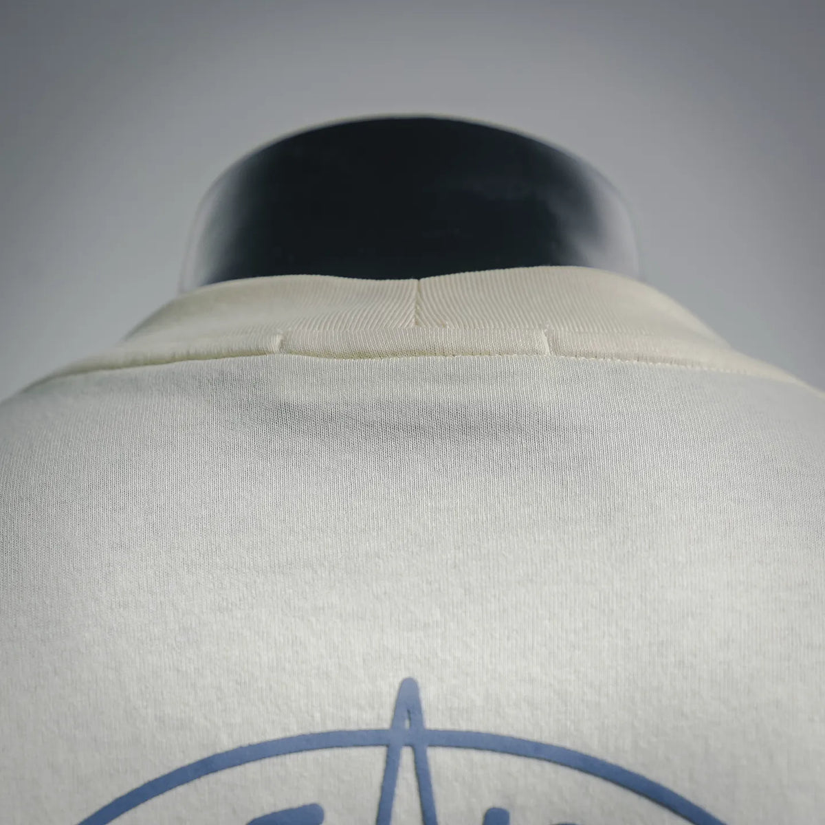 Light cream T-shirt neckline and collar seam detail on back side
