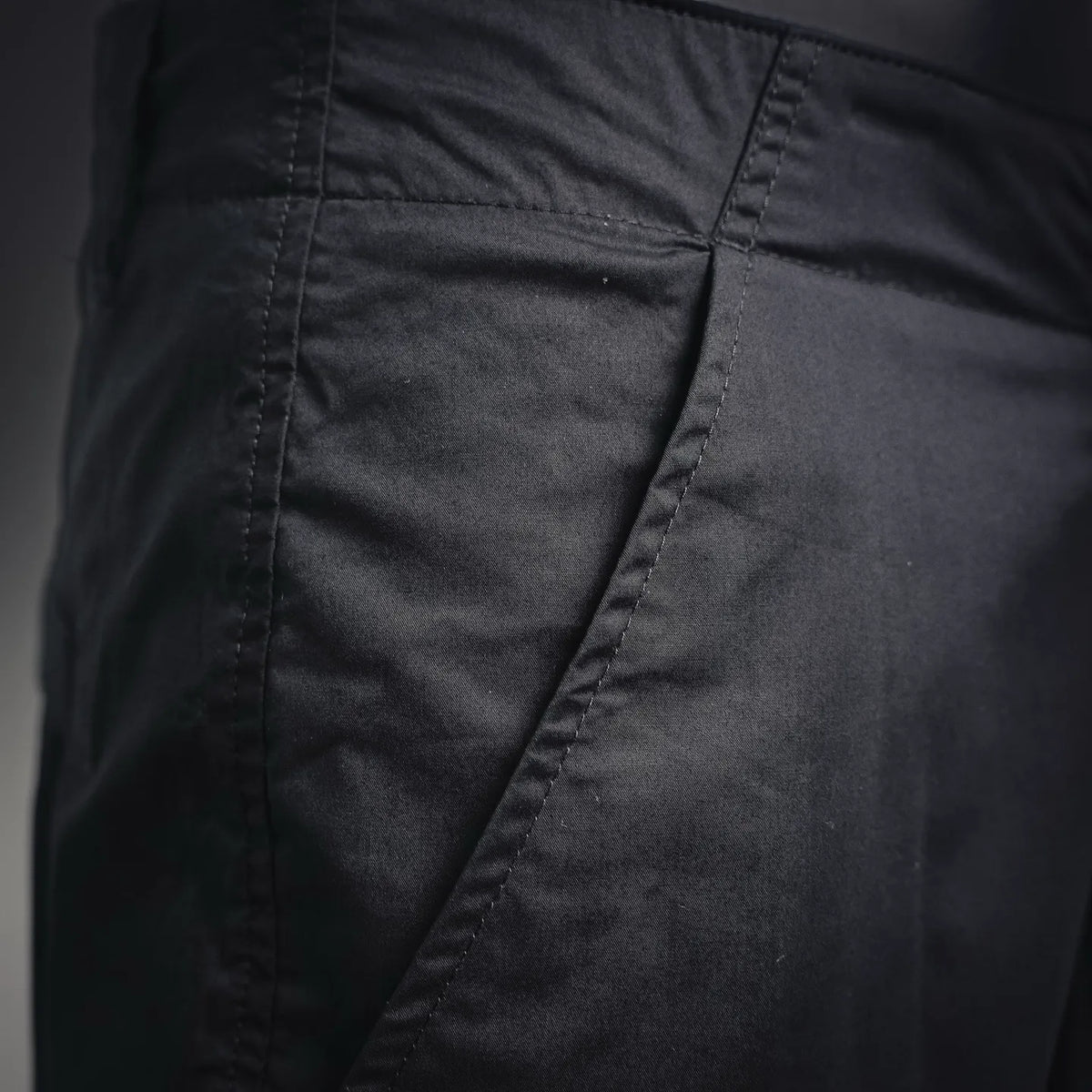 Black pants with diagonal pocket panel and reinforced stitching