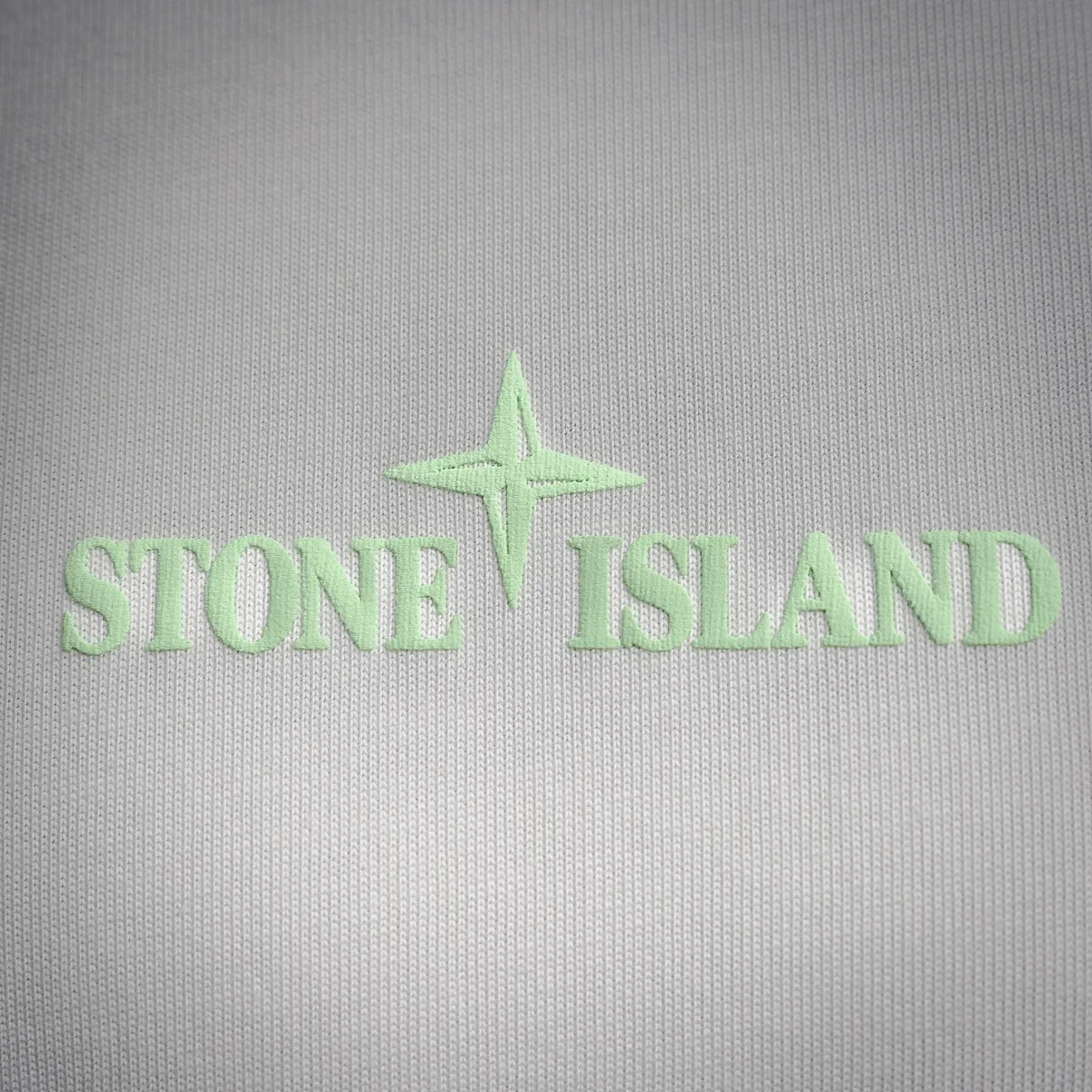 Green Stone Island logo and star embroidered on the fabric