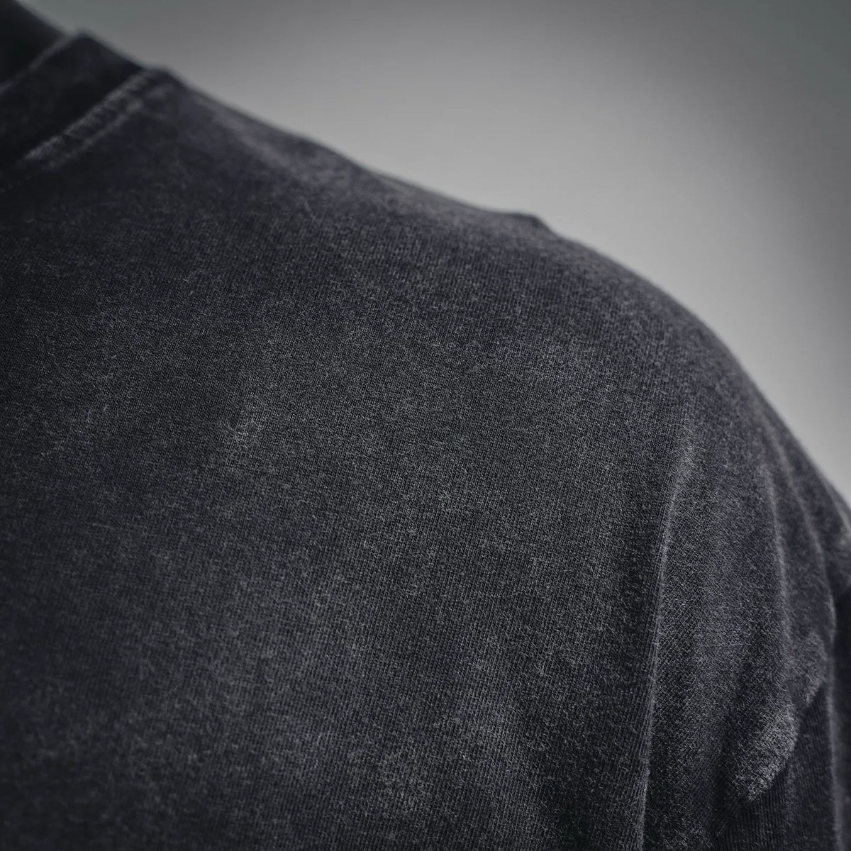 Stone Island black T-shirt fabric texture, close-up of shoulder and sleeve