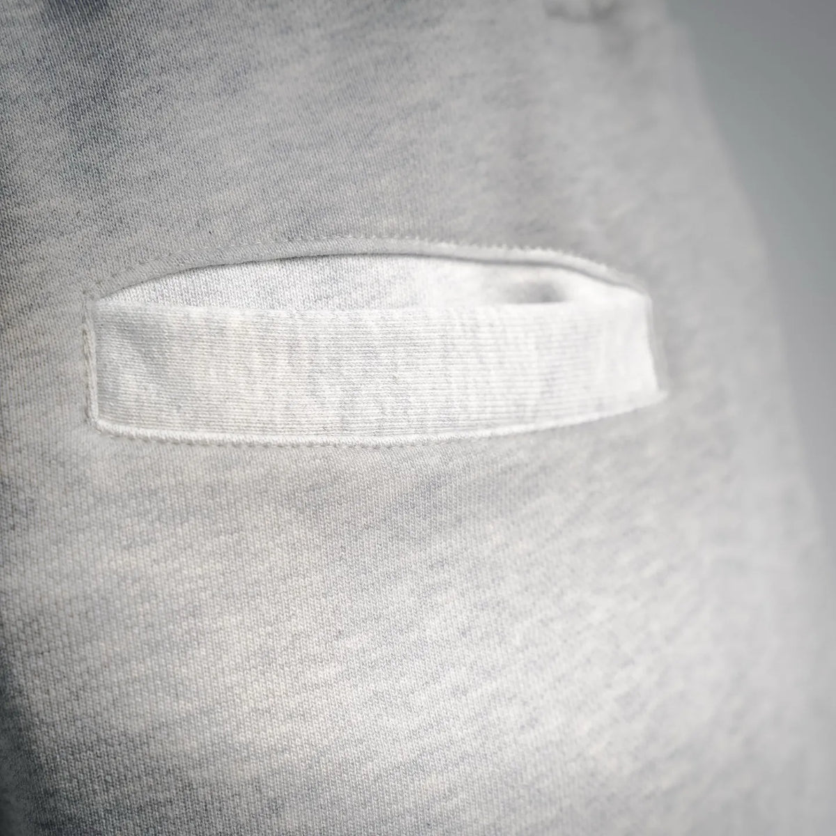 Light gray shorts pocket opening with curved welt and neat stitching