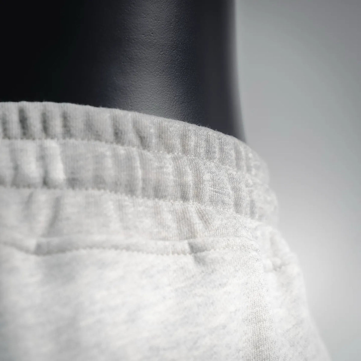 Light gray elastic waistband with gathered seams, close-up knit texture