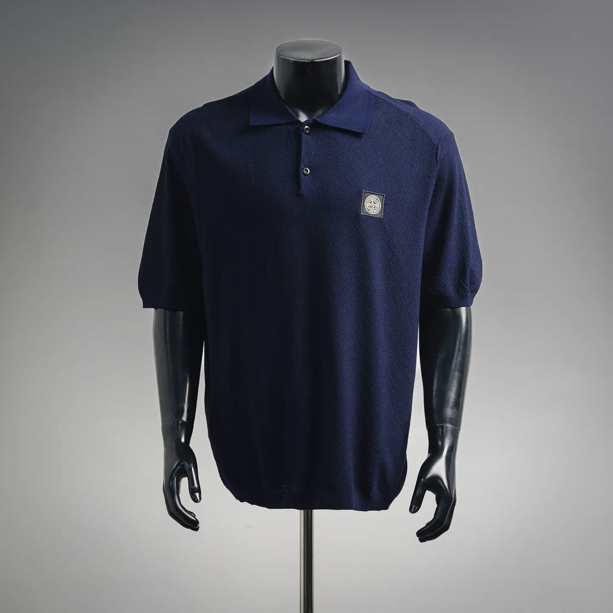 Navy short-sleeve polo shirt with button placket and small chest logo patch
