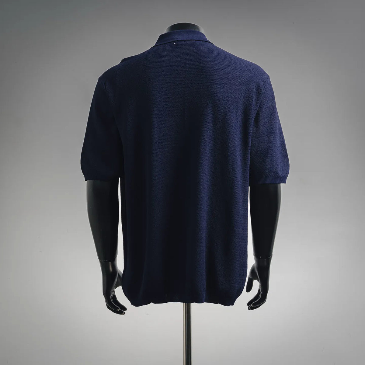 Navy short-sleeve polo shirt, back view on mannequin with knit texture