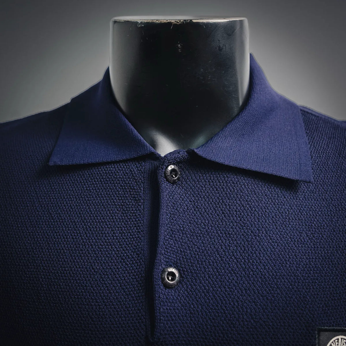 Navy polo collar with two-button placket and woven chest logo patch