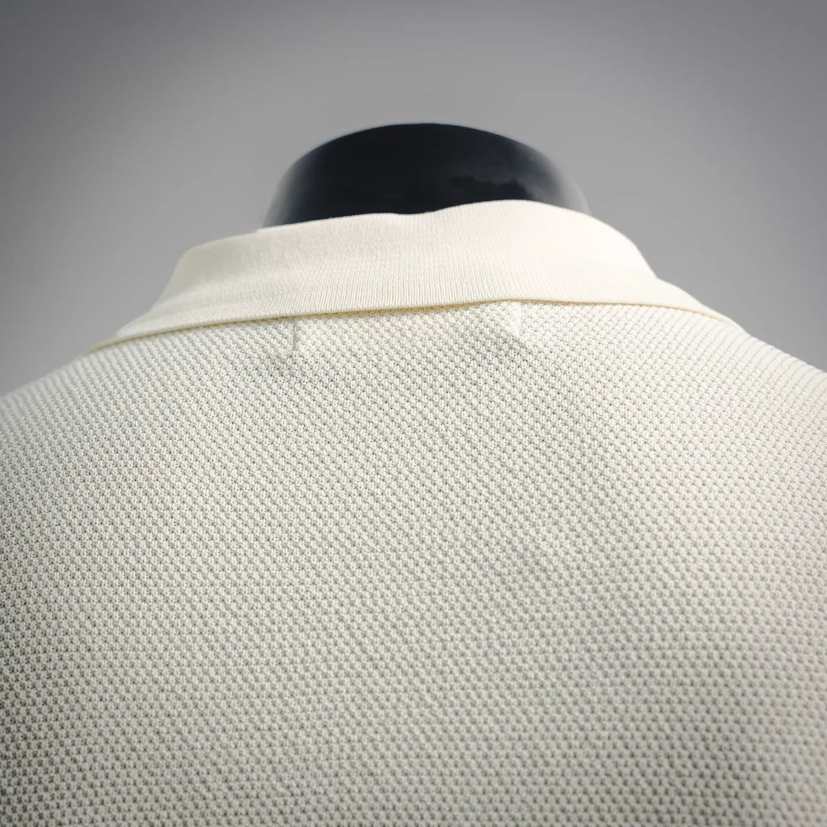 Stone Island polo shirt back yoke, off-white textured knit fabric.