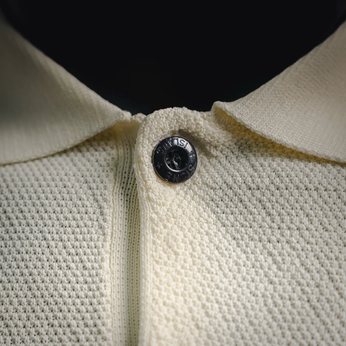 Stone Island polo shirt placket with button, off-white textured knit collar.