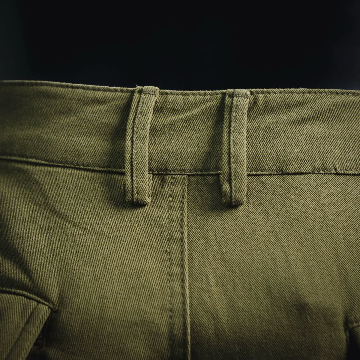 Stone Island cargo pants close-up of waistband and front button placket in olive green
