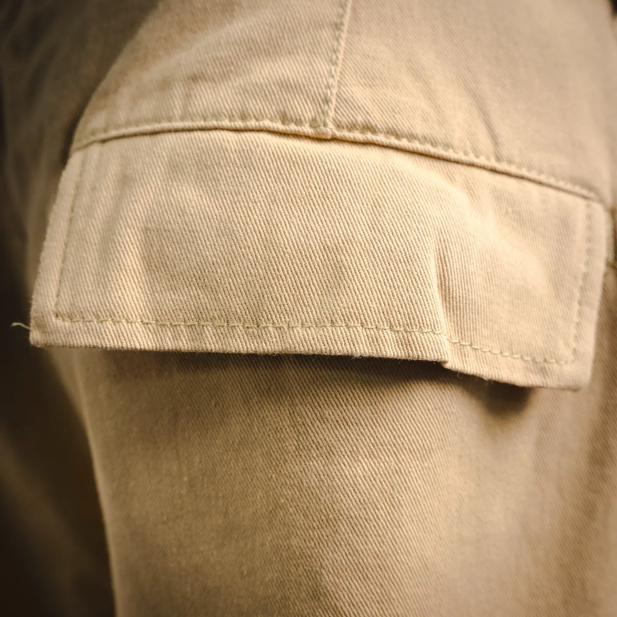 Tan pants hem with visible stitching and folded cuff detail